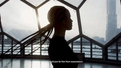a woman with dreadlocks standing in front of a window