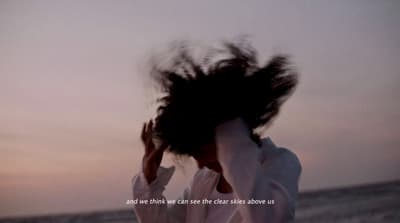 a woman with her hair blowing in the wind