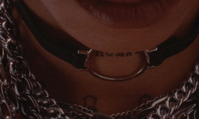 a close up of a person with a chain around their neck