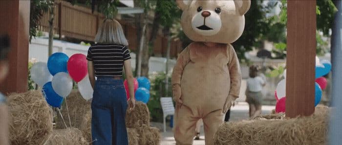 a woman standing next to a giant teddy bear