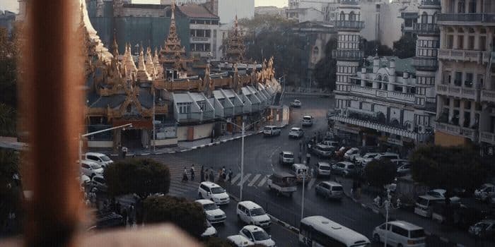 a city street filled with lots of traffic next to tall buildings