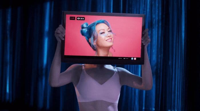 a woman holding up a television with a picture of a woman on it