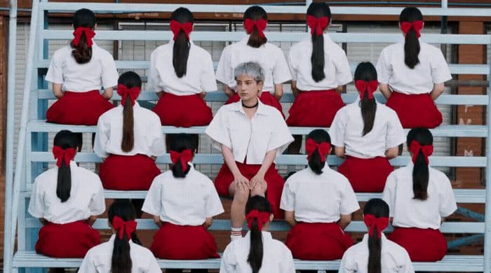 a group of women sitting on top of a bleachers