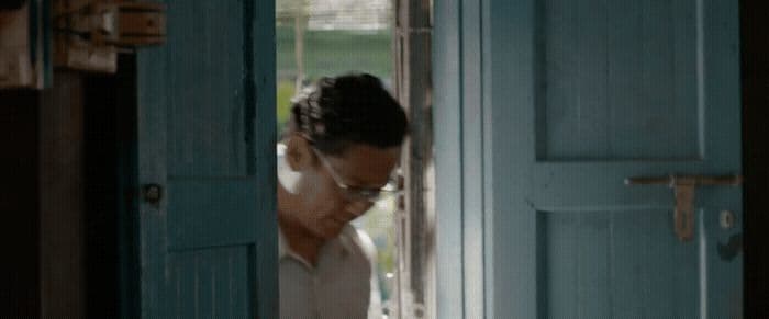 a woman standing in a doorway talking on a cell phone