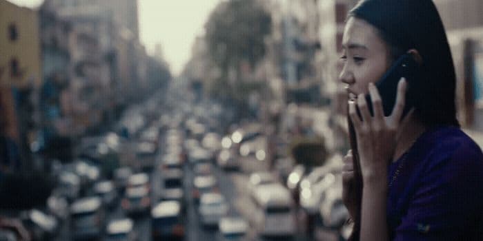 a woman talking on a cell phone next to a busy street