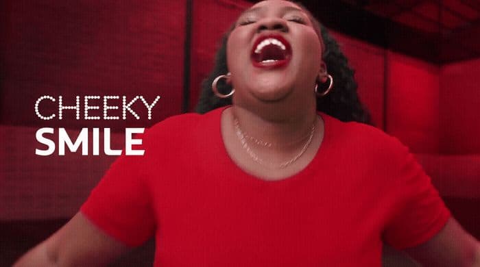 a woman in a red shirt singing into a microphone