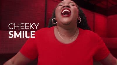 a woman in a red shirt singing into a microphone