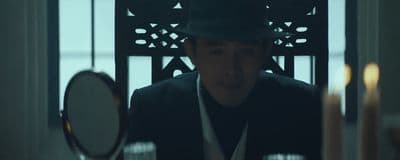 a man in a hat is looking at a mirror