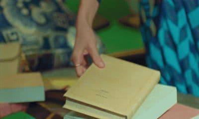 a person reaching for a book on a table