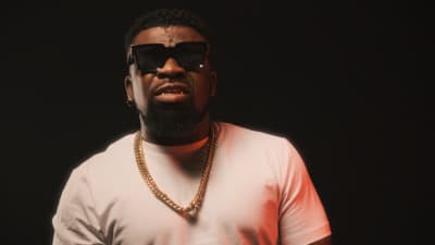 a man wearing sunglasses and a gold chain