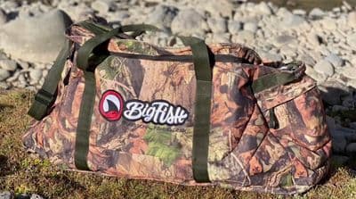 a duffel bag sitting on the ground next to rocks
