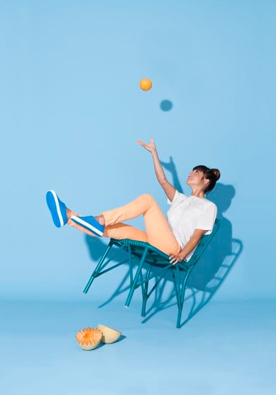 a woman is sitting in a chair with a tennis racket