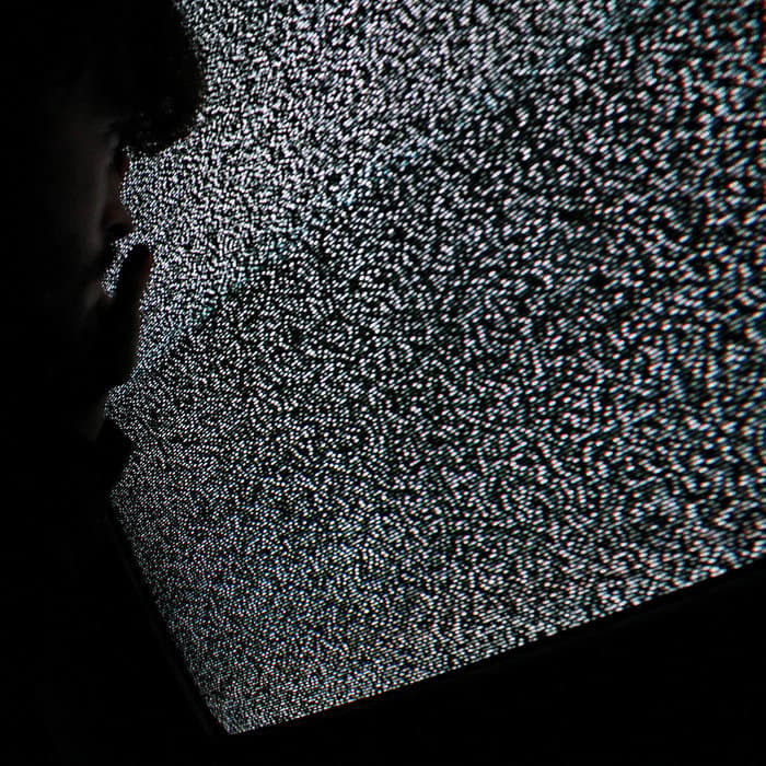 a man standing in front of a television screen