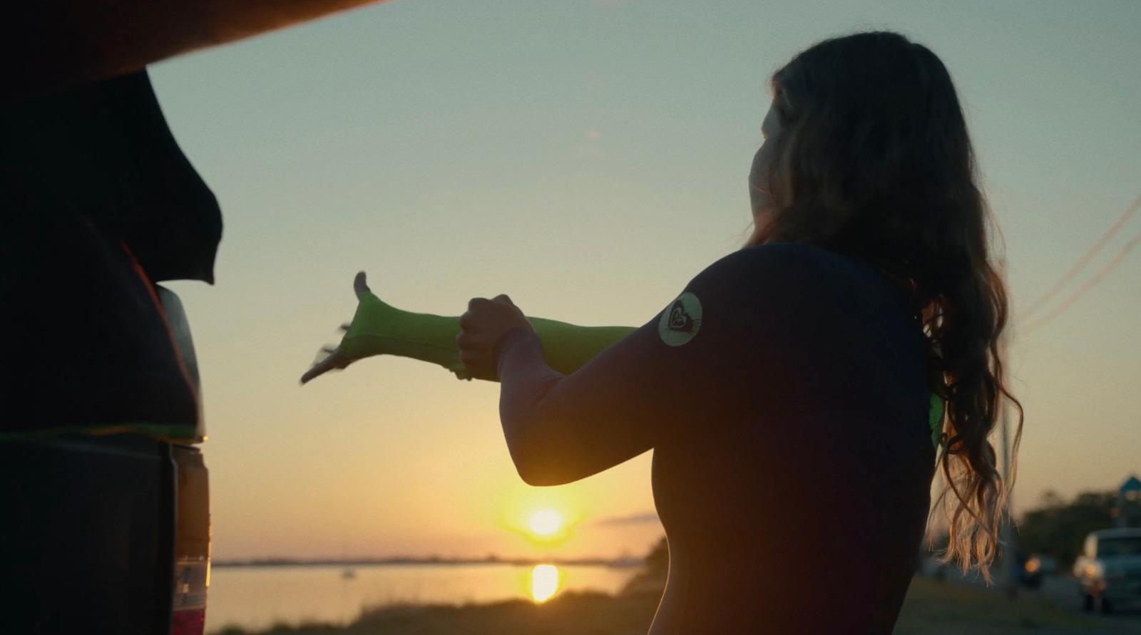 a woman in a wet suit holding a banana