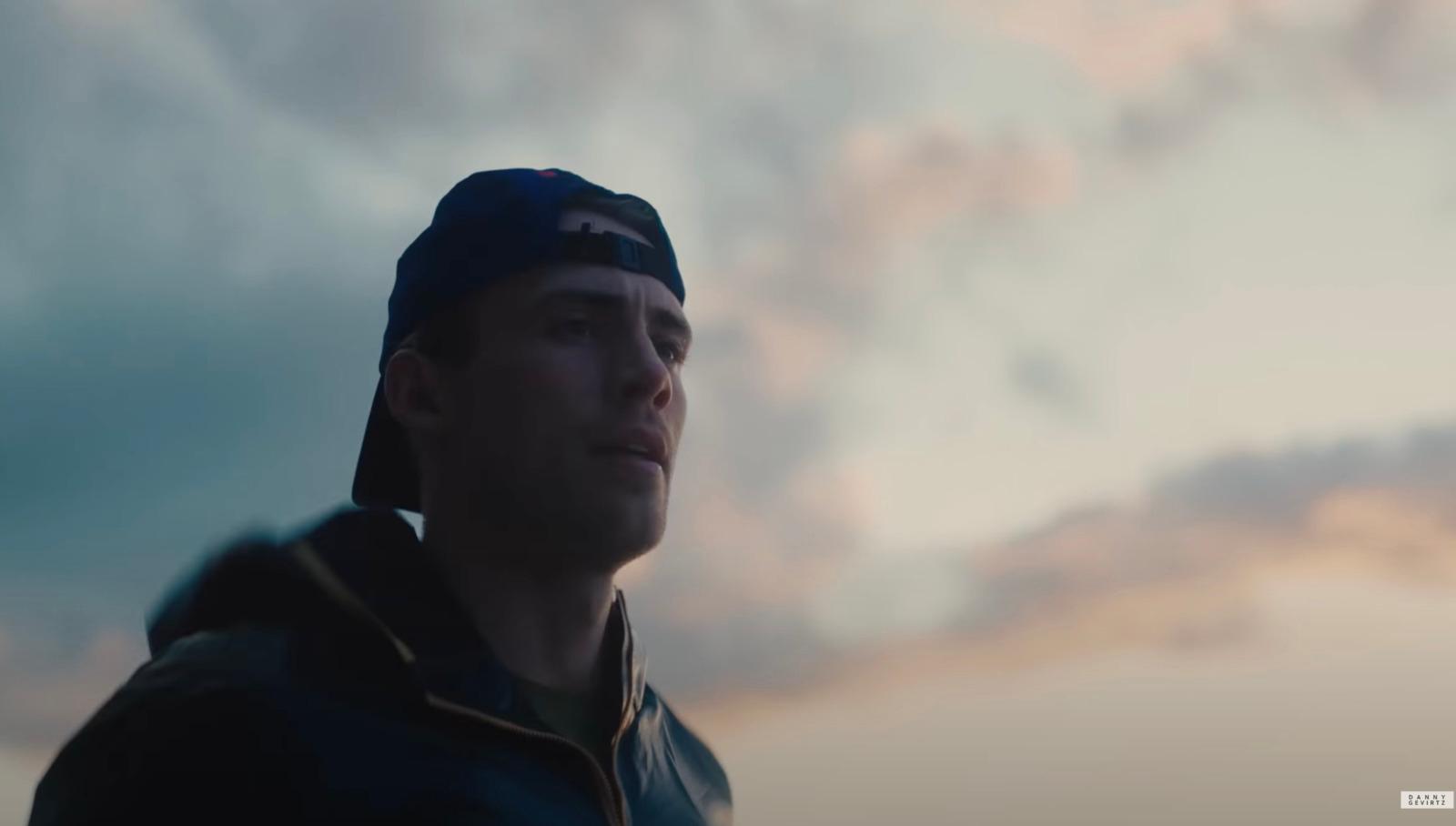 a man in a baseball cap looking away from the camera