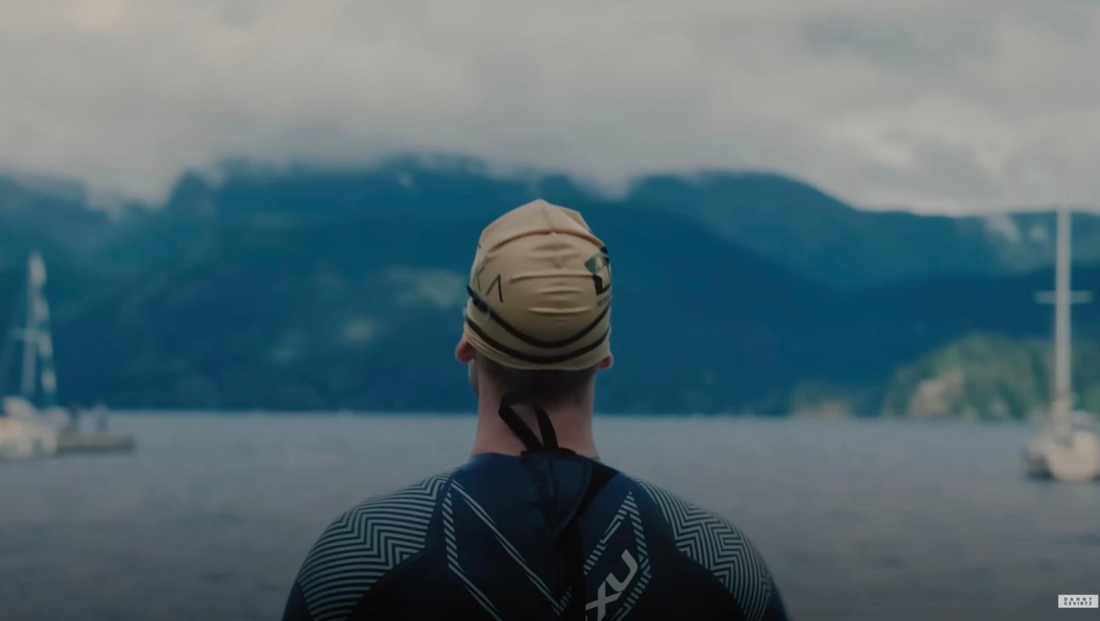 a man wearing a hat looking out over a body of water