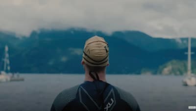 a man wearing a hat looking out over a body of water