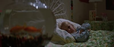 a little girl laying in a bed with a pillow