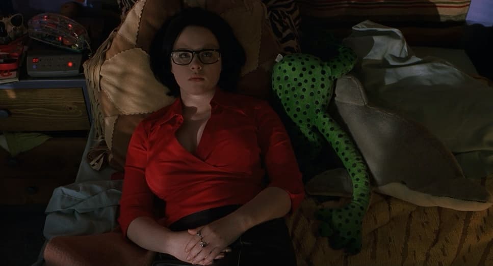 a woman in a red shirt is laying on a bed