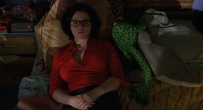 a woman in a red shirt is laying on a bed