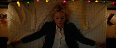 a woman laying in a bed with christmas lights