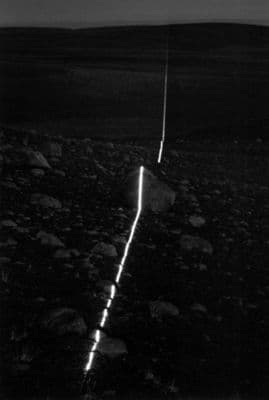 a black and white photo of a long line of lights