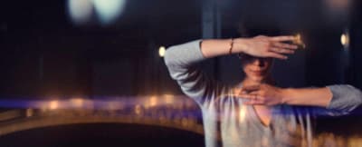a man standing in front of a mirror holding his hand up to his head