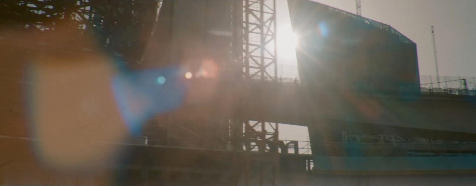 a blurry photo of a bridge with the sun in the background