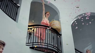 a woman in a pink dress standing on a balcony