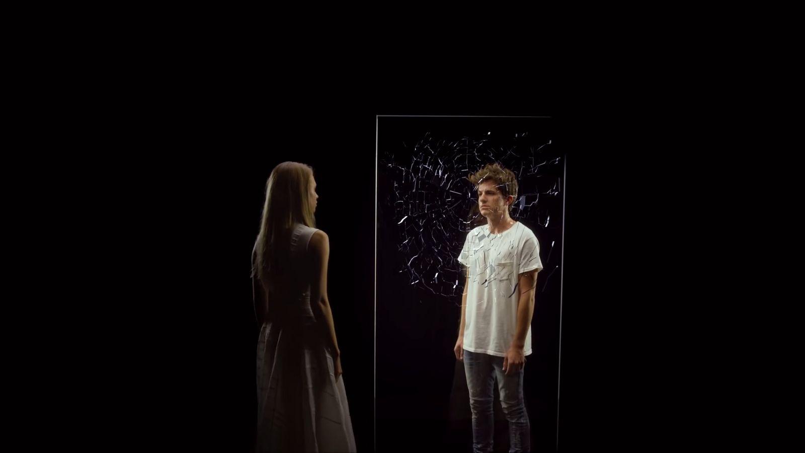 a man and a woman standing in front of a mirror