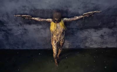 a woman with her arms spread out in front of a dark background