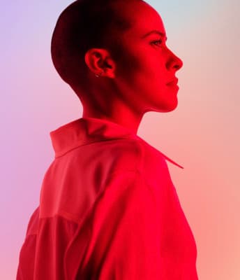 a woman in a red shirt looking off into the distance