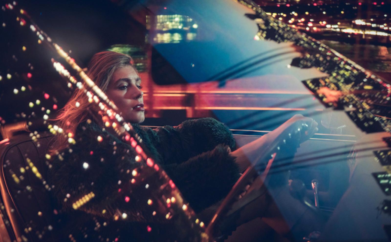 a woman is sitting in a car at night
