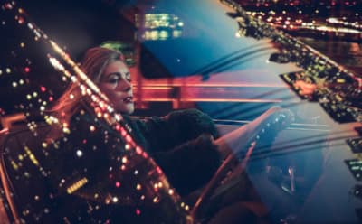 a woman is sitting in a car at night