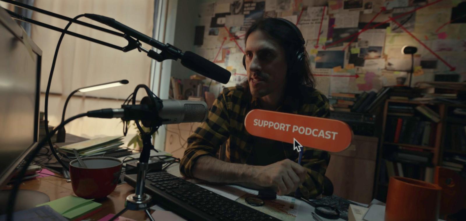 a man sitting at a desk in front of a microphone