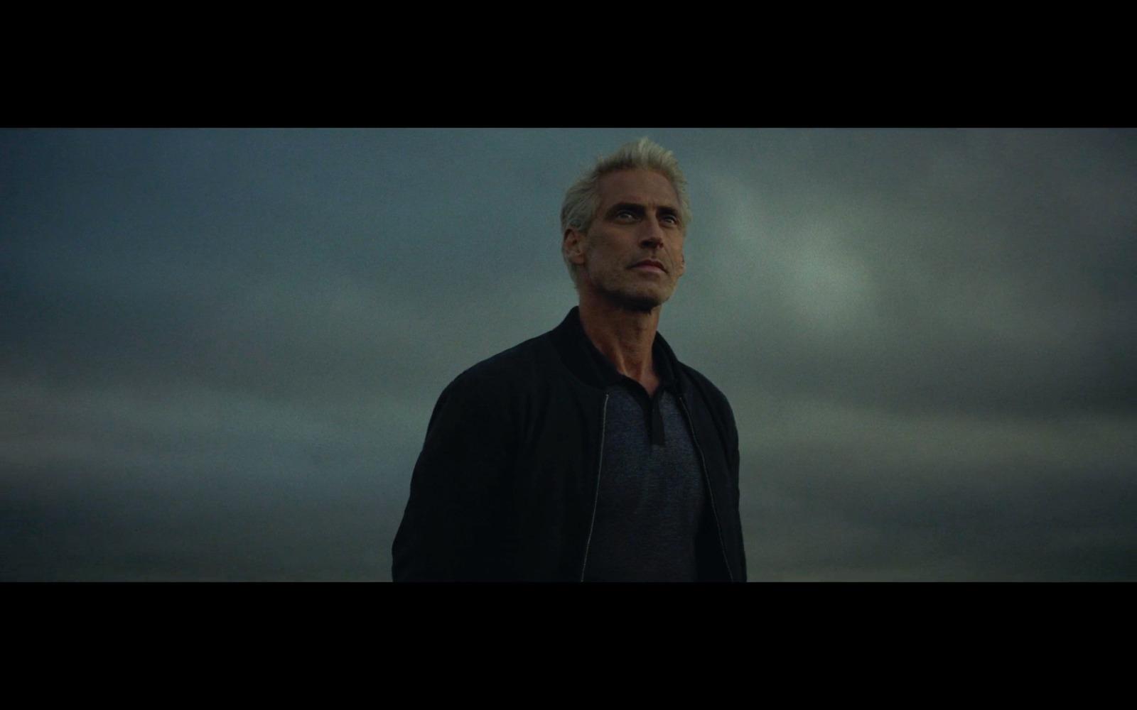 a man standing in front of a cloudy sky