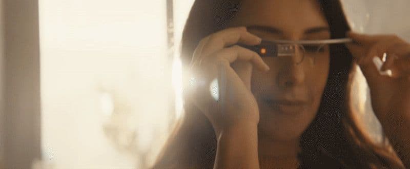 a woman holding a pair of glasses up to her face