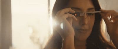 a woman holding a pair of glasses up to her face