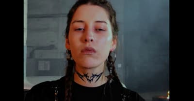 a woman with long braids wearing a black shirt