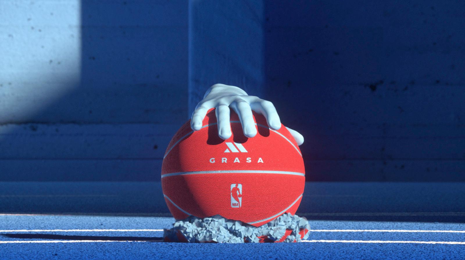 a hand holding a red ball on top of a tennis court