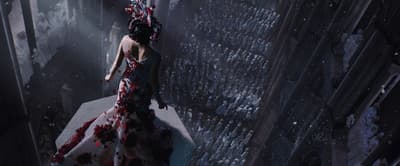 a woman in a long dress standing on a ledge