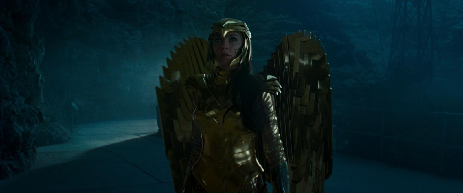 a woman dressed as a golden throne in a dark forest