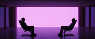 a couple of people sitting in chairs in a room