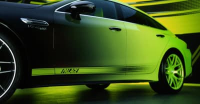 a green car parked in front of a yellow wall