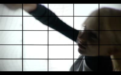 a woman holding her hand out in front of a tiled wall