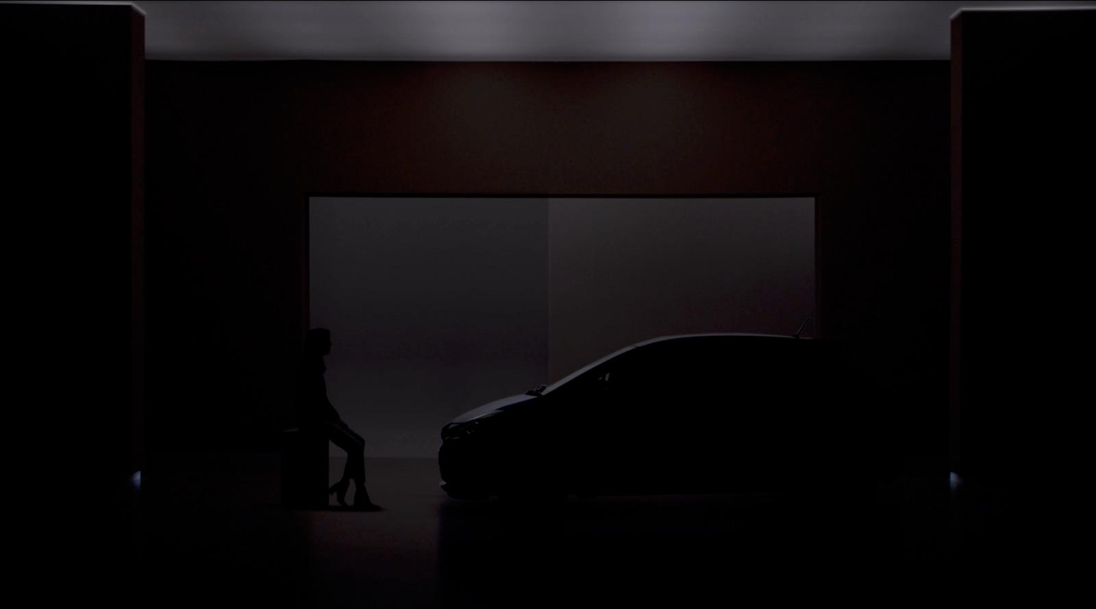 a woman sitting on a stool next to a car