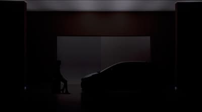 a woman sitting on a stool next to a car