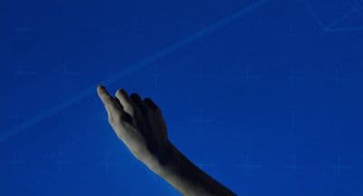 a person's hand reaching up into the sky