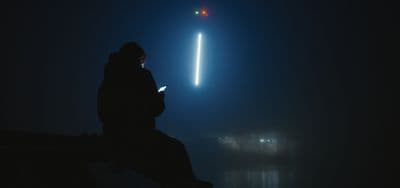 a person sitting on a bench looking at a cell phone
