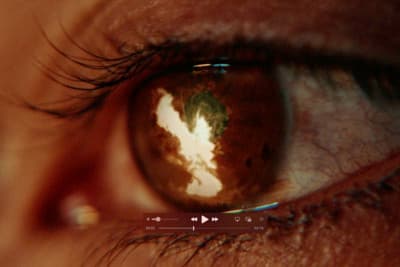 a close up of a person's eye with the reflection of a cloud in